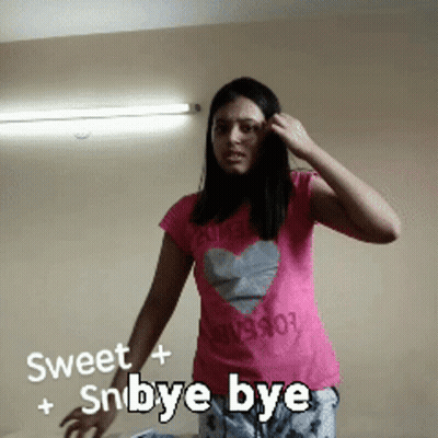 Woman In Pink Shirt With Heart Saying Sweet + Snbye Bye GIF