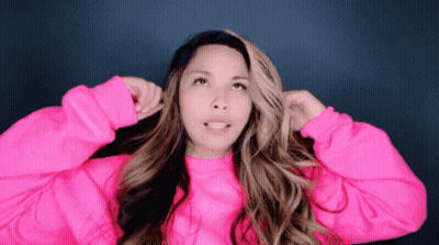 Woman In Pink Sweater Holding Hair Up GIF