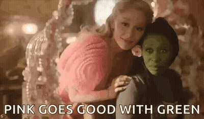 Woman In Pink Sweater Sitting Next To Green Girl GIF