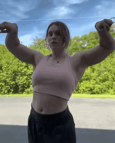Woman In Pink Tank Flexing Arms GIF