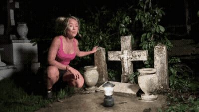 Woman In Pink Tank Top Squatting At Grave GIF