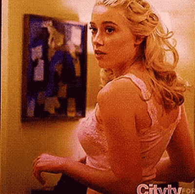 Woman In Pink Tank Top Standing In Front Of Wall With Picture GIF