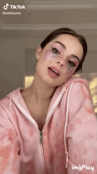 Woman In Pink Tie Dye Hoodie Looking At Camera GIF