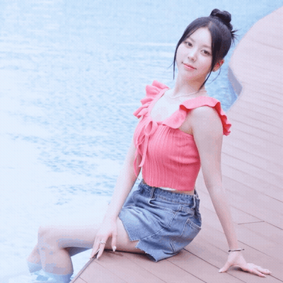 Woman In Pink Top And Denim Skirt By Pool GIF