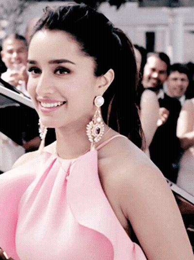 Woman In Pink Top And Earrings Smiling GIF