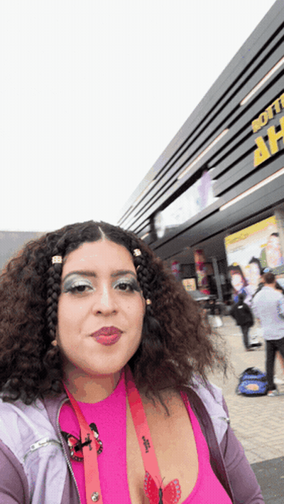Woman In Pink Top In Front Of Soft Building GIF