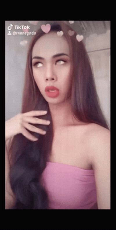 Woman In Pink Top With Hearts On Hair Says TikTok GIF