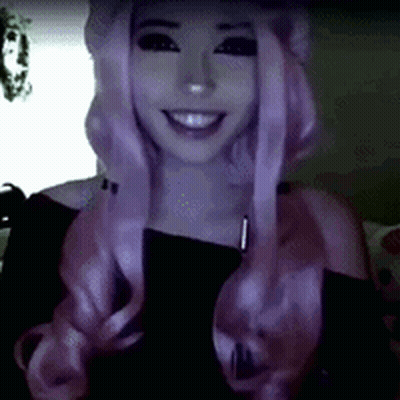 Woman In Pink Wig And Black Top Smiling GIF
