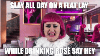 Woman In Pink Wig Making Funny Face Drinking Rose GIF