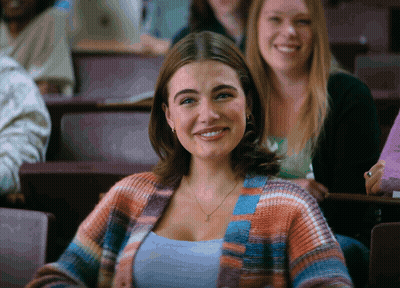 Woman In Plaid Cardigan Smiling In Classroom GIF