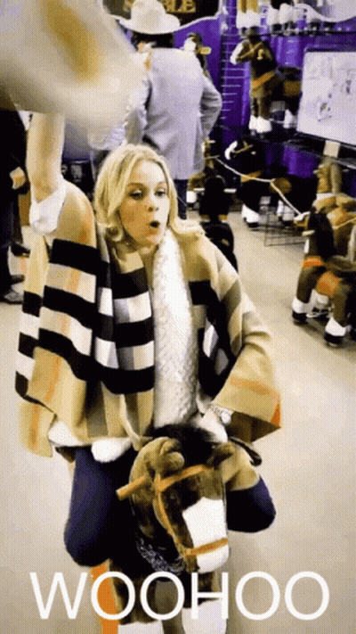 Woman In Plaid Coat Holding Stuffed Horse Saying Woohoo GIF