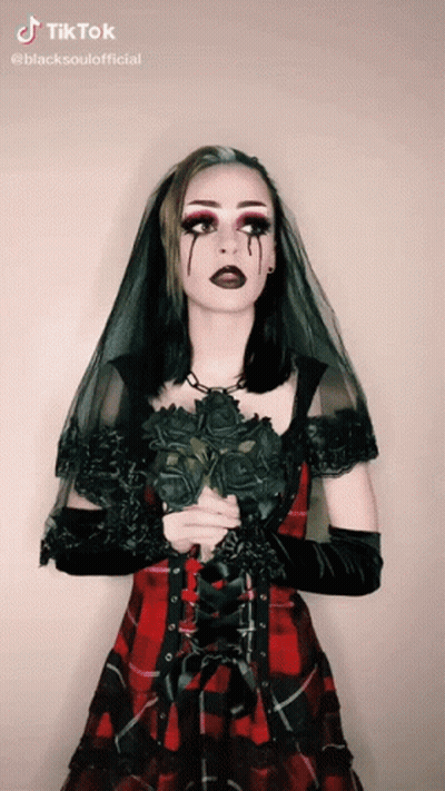 Woman In Plaid Dress Holding Black Roses GIF
