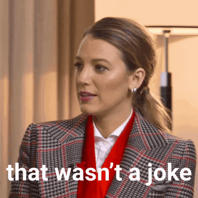 Woman In Plaid Jacket And Red Scarf Says That Wasn't A Joke GIF