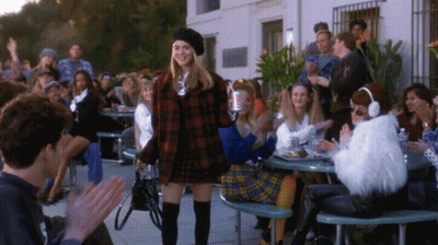Woman In Plaid Jacket Before Crowd GIF