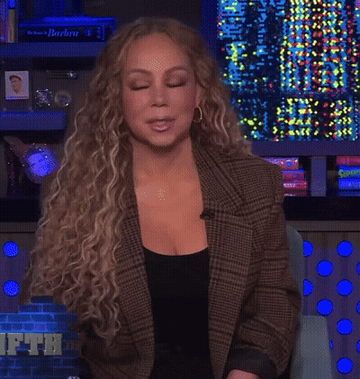 Woman In Plaid Jacket In Front Of Barbra Wall GIF
