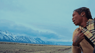Woman In Plaid Scarf Standing In Front Of Mountain GIF