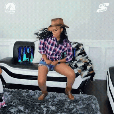 Woman In Plaid Shirt And Cowboy Hat Dancing In Front Of Paramount Poster GIF