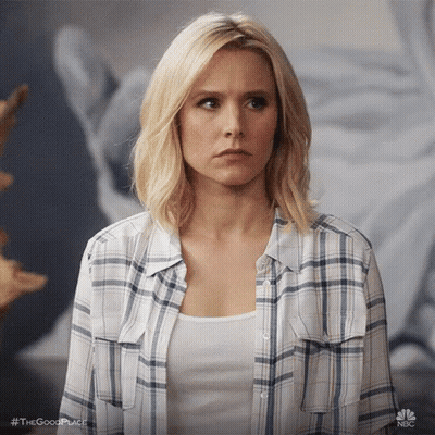 Woman In Plaid Shirt And White Tank Top Looking At Camera GIF