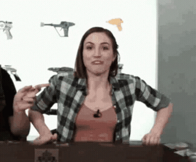 Woman In Plaid Shirt At Table With Man Behind GIF