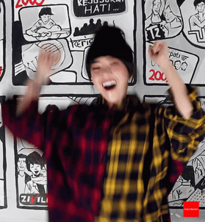 Woman In Plaid Shirt In Front Of Cartoon Wall GIF