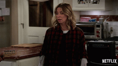 Woman In Plaid Shirt In Kitchen With Netflix Logo GIF