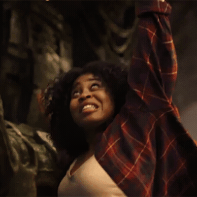 Woman In Plaid Shirt Raising Arms Smiling GIF