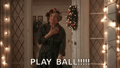 Woman In Plaid Shirt Says Play Ball By Christmas Lights GIF