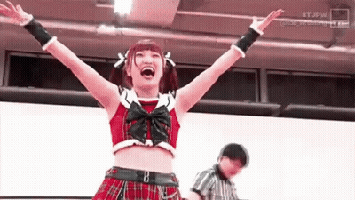 Woman In Plaid Skirt Raising Arms While Referee Watches GIF