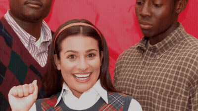 Woman In Plaid Vest Smiling With Two Men GIF