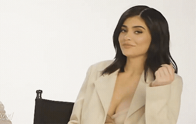 Woman In Plunging Neckline Sitting In Chair GIF