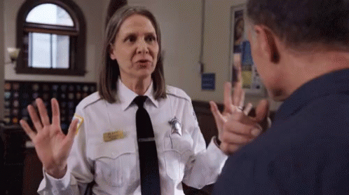 Woman In Police Uniform Talking To Man In Prison Cell GIF