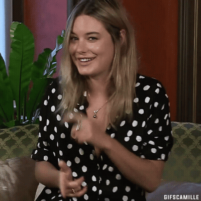 Woman In Polka Dot Dress Smiling On Couch GIF