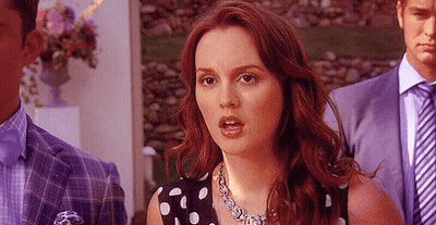 Woman In Polka Dot Dress Standing Before Man In Suit GIF