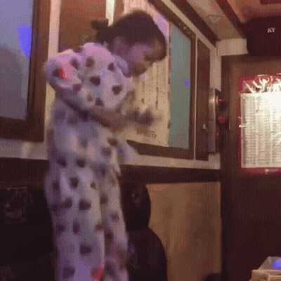 Woman In Polka Dot Pajamas Standing Near Ky Sign GIF