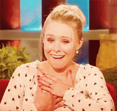 Woman In Polka Dot Shirt Smiling Holding Chest GIF