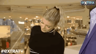 Woman In Ponytail Talking To Man In Suit In Store GIF