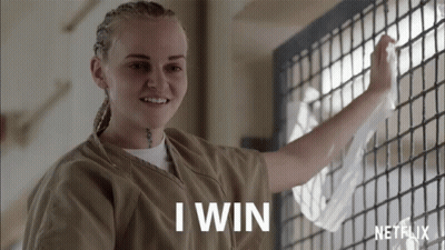 Mujer en uniforme de prisión sonriendo: gané GIF