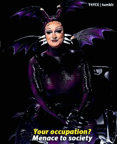 Woman In Purple And Black Costume Saying Your Occupation GIF