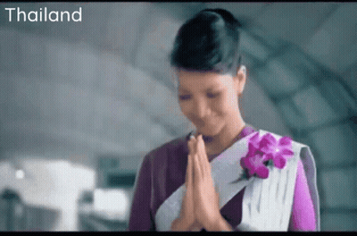 Woman In Purple And White Dress Praying By Thailand Sign GIF