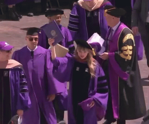 Woman In Purple Cap And Gown Holding Diploma With Letter S GIF