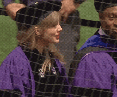 Woman In Purple Cap And Gown Next To Man In Black Hat GIF