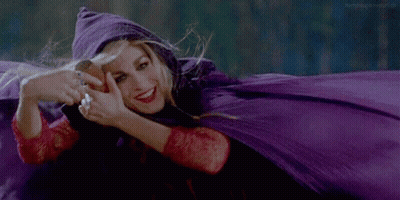 Woman In Purple Cape Smiling While Laying Down GIF