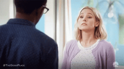 Woman In Purple Cardigan Looking At Man In Blue Shirt GIF