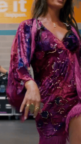 Woman In Purple Dress Dancing In Front Of Exit Sign GIF