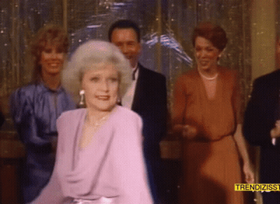 Woman In Purple Dress Dancing In Front Of Trendizss Sign GIF