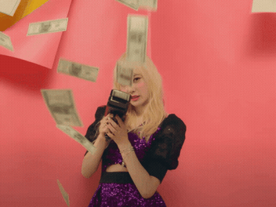 Woman In Purple Dress Holding Camera Surrounded By Money GIF