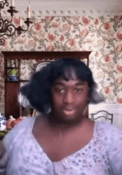 Woman In Purple Dress In Dining Room With Floral Wallpaper GIF