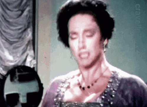 Woman In Purple Dress Looking In Mirror GIF