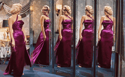 Woman In Purple Dress Looking In Mirror GIF
