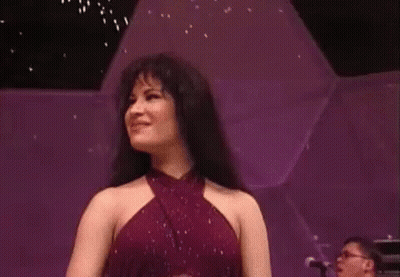 Woman In Purple Dress Smiling On Stage With Piano Player GIF